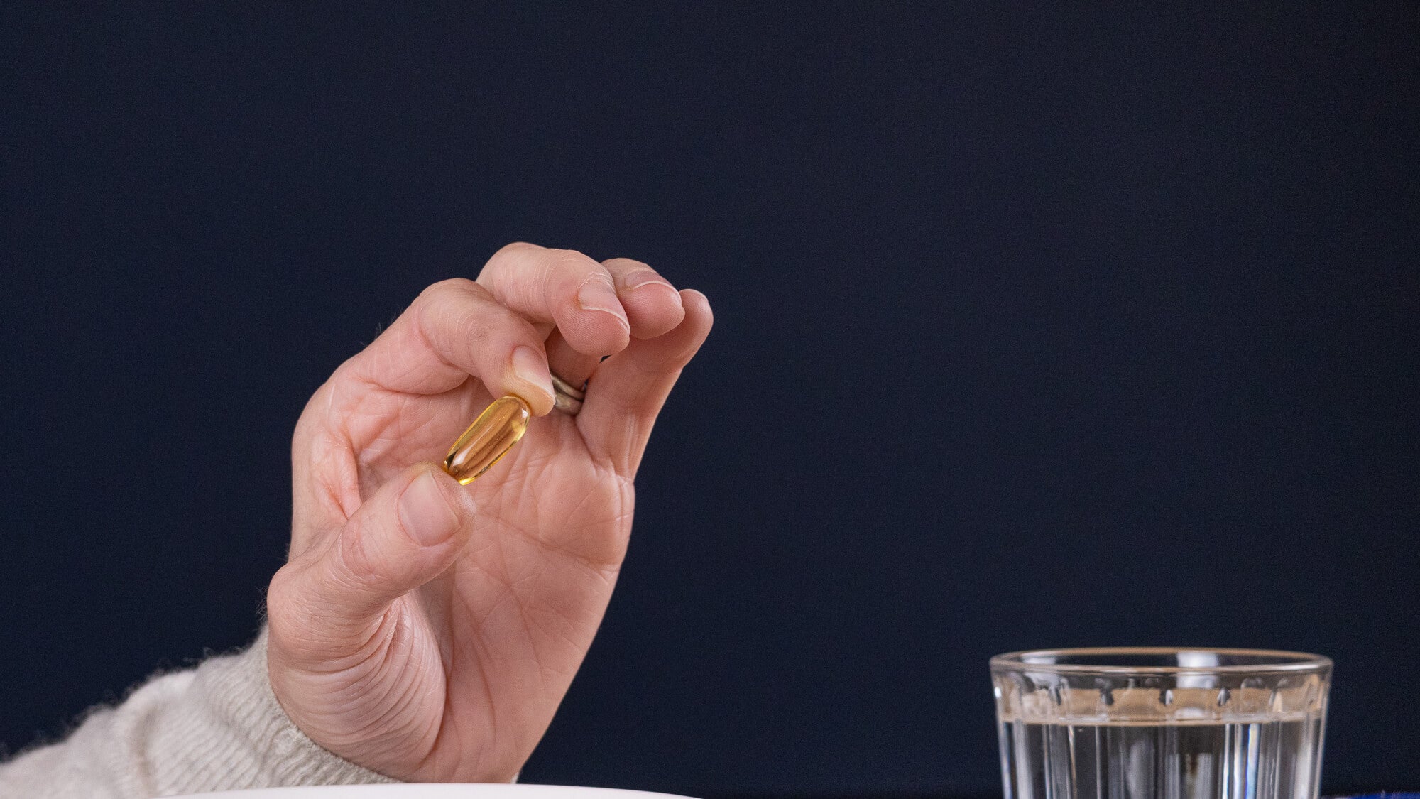 Efamol evening primrose oil 1000mg capsule in hand background Efamol evening primrose oil 1000mg capsule in hand background
