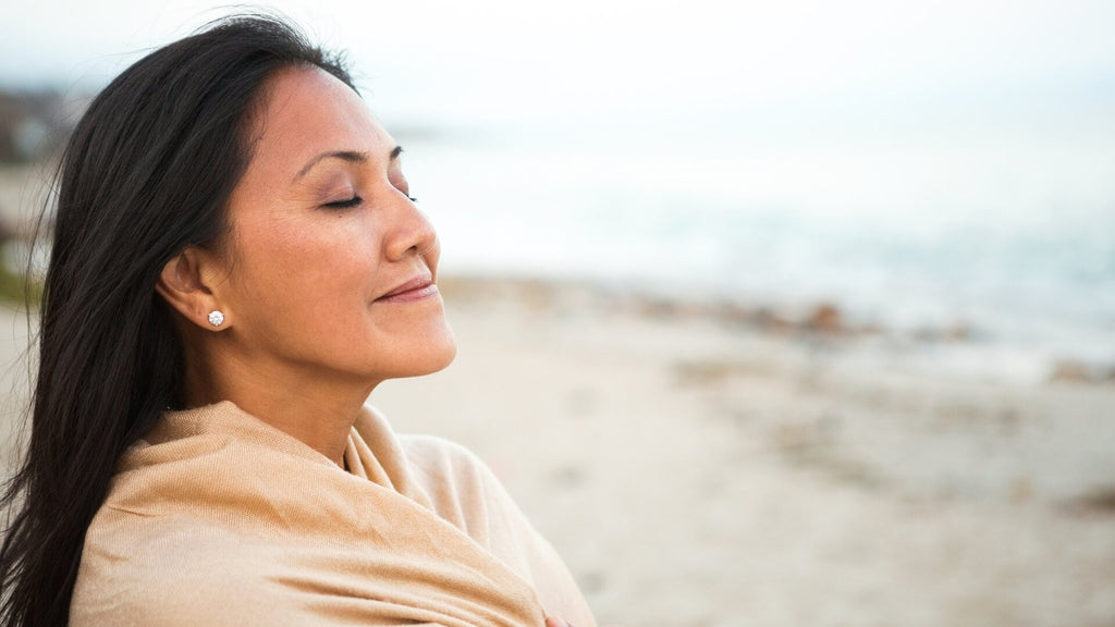 menopausal woman breathing in fresh air at the beach