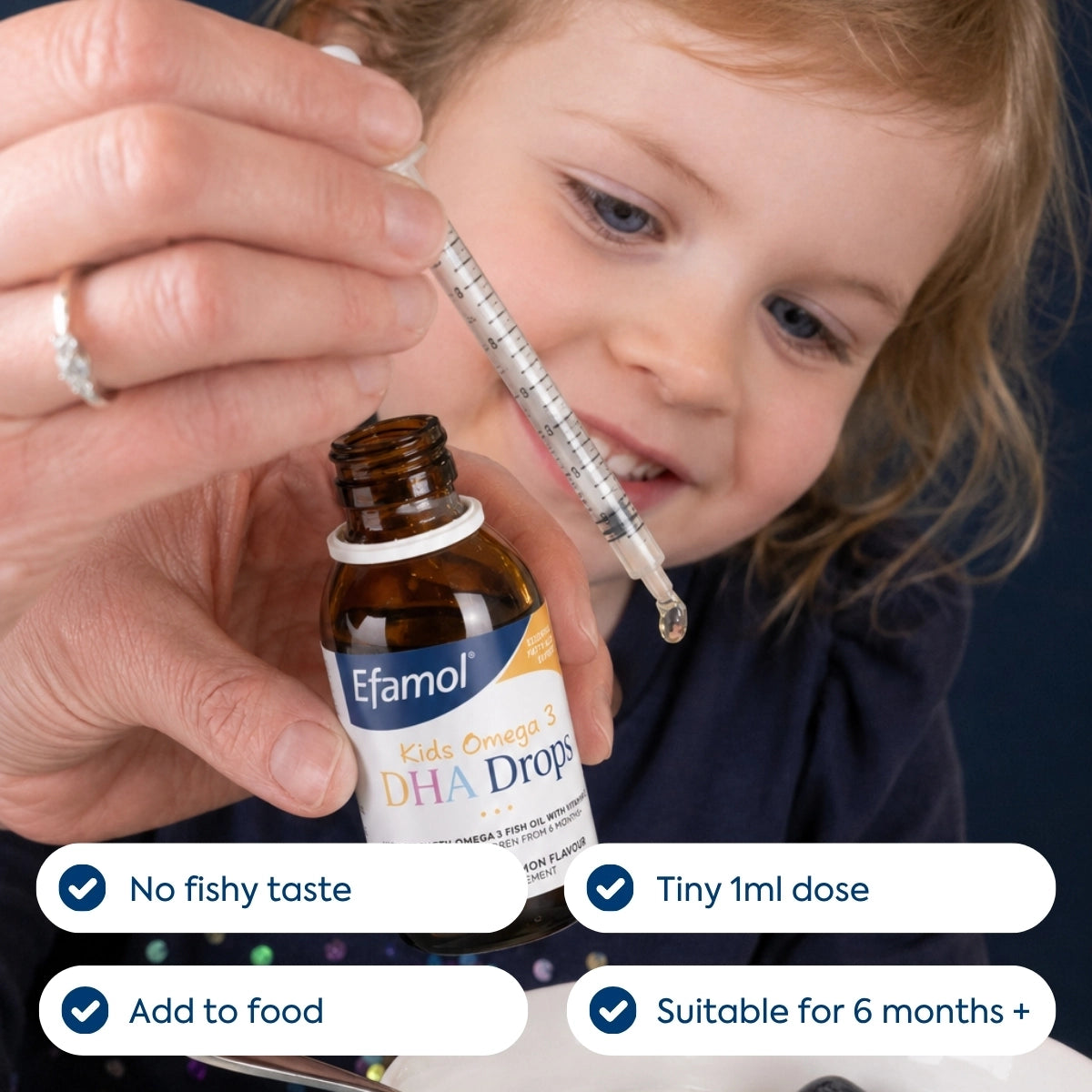 Person administering Efamol DHA Drops to a child using a syringe.
