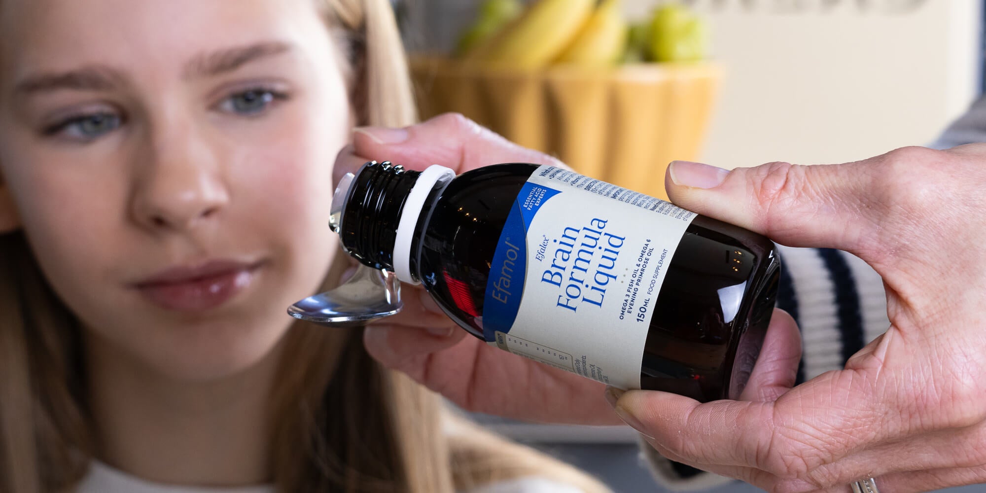 Efalex brain formula liquid, pouring into spoon for child